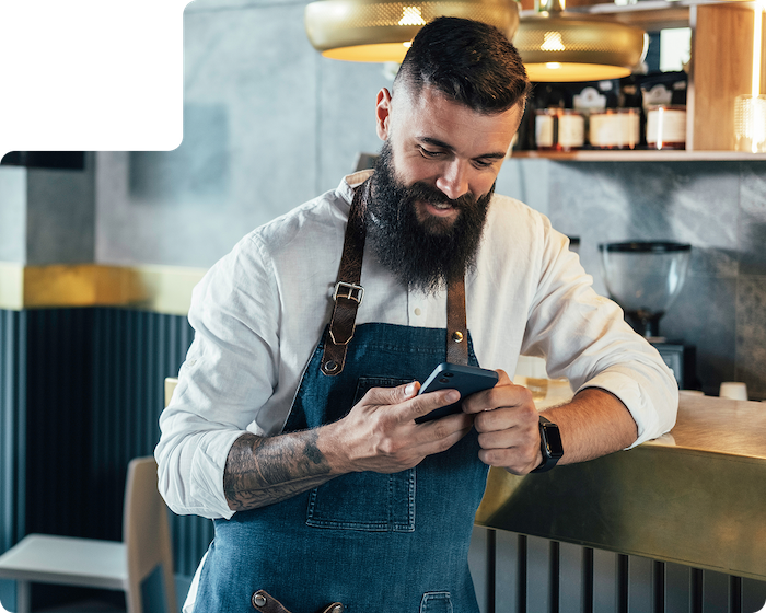 Medarbetare i ett kafé läser på mobilen